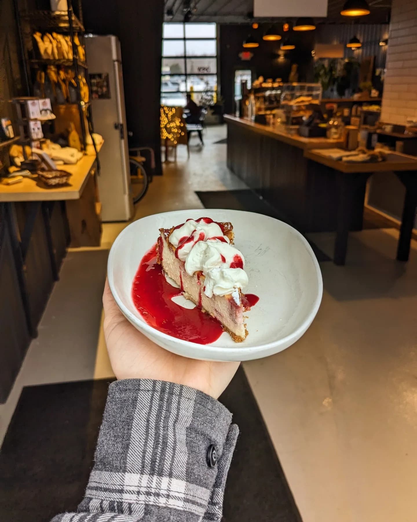 Cheesecake with whipped cream and berry sauce